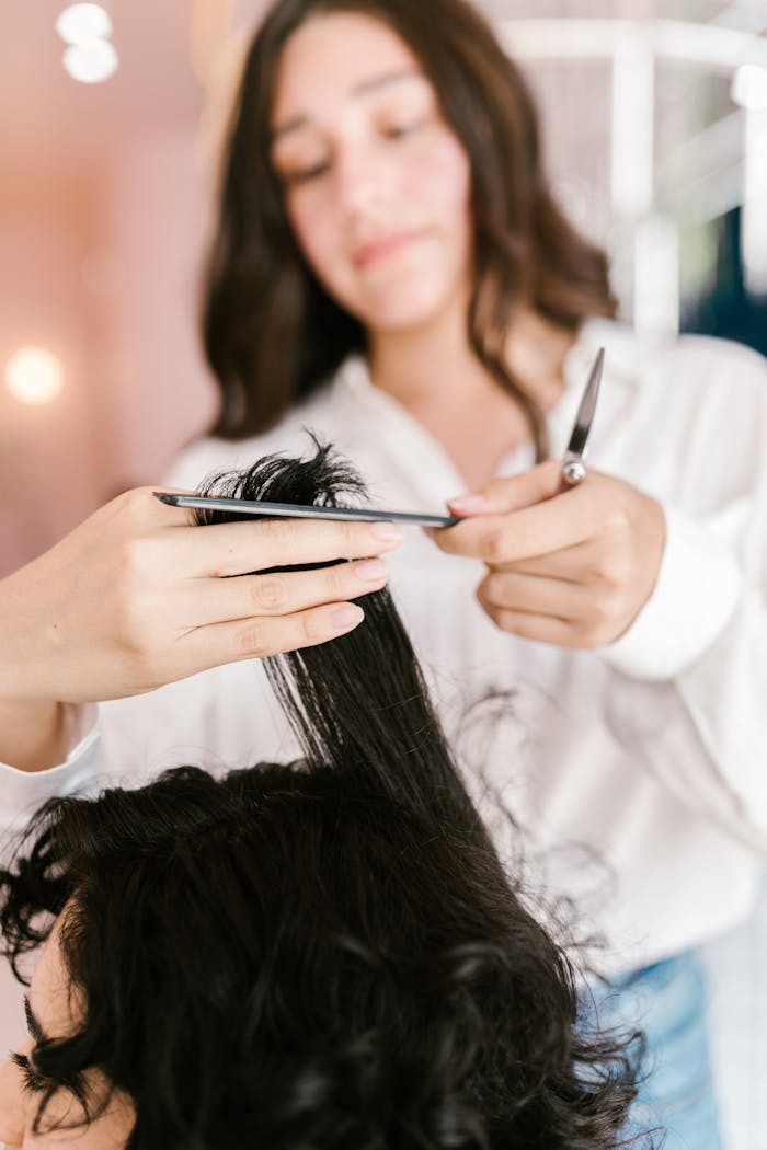 about-img Close-up of hairstylist expertly cutting client’s hair in a salon setting.